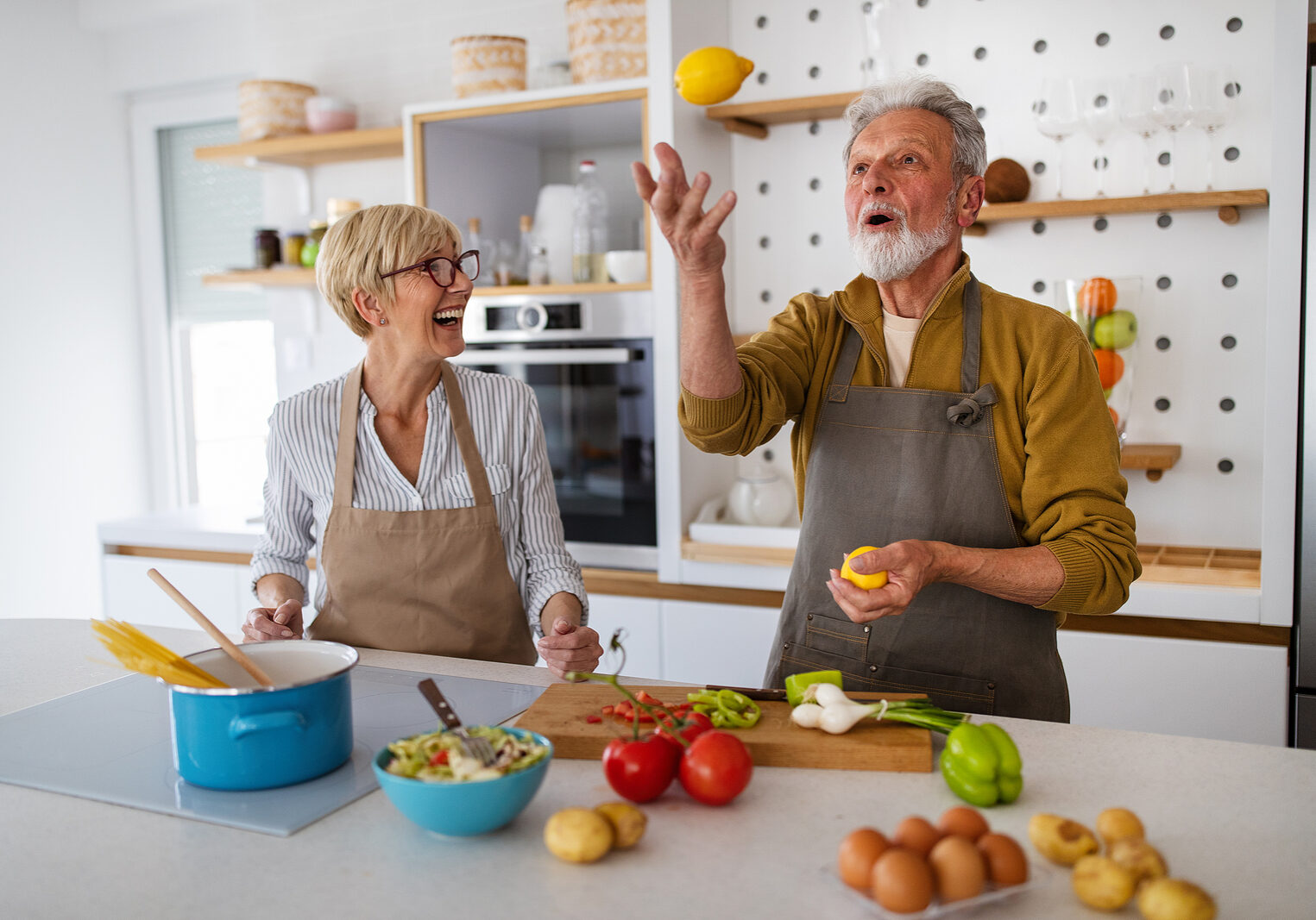 Senior Couple Having Fun, Cooking Together In Home Kitchen DENTAL, VISION, HEARING PLANS NEAR ME